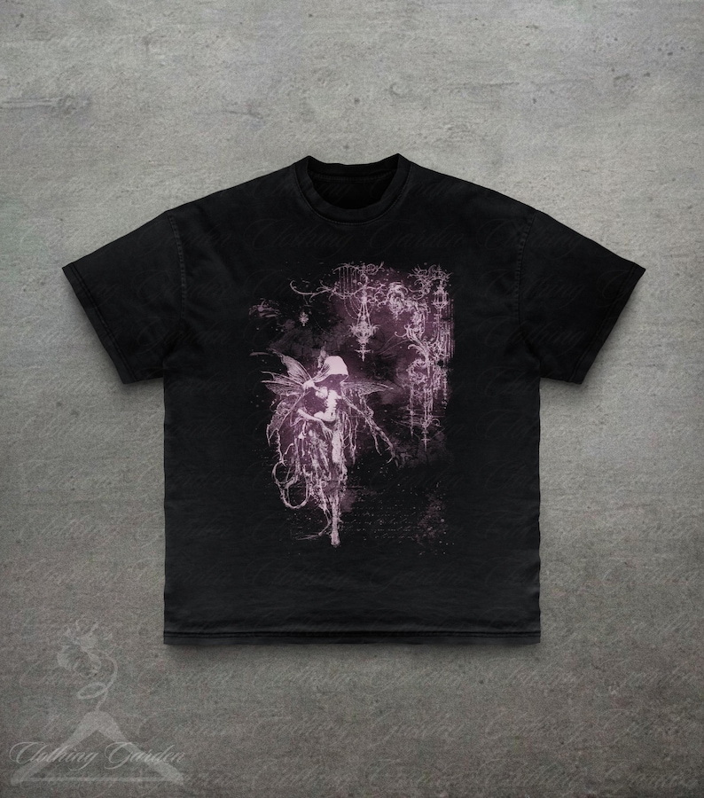 May include: Black t-shirt with a gothic fairy illustration in purple and white. The design features detailed imagery and a dark, ethereal style. The shirt has a classic crew neck and short sleeves. The t-shirt is made of a soft material.
