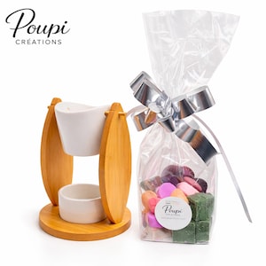 Peut inclure: Un diffuseur d'huiles essentielles en bambou avec deux bols en céramique blanche et un sac en cellophane transparent noué avec un nœud argenté, rempli de fondants parfumés colorés. Le sac porte l'inscription "Poupi Créations".