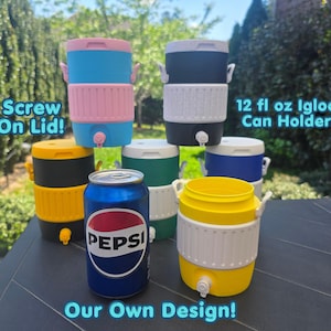 Puede incluir: Una colección de coloridos portabotellas Igloo de 355 ml. Los soportes están disponibles en azul, rosa, amarillo, negro y verde. Cada uno tiene una tapa de rosca y un grifo. También se ve una lata de Pepsi. El texto de la imagen dice "Screw On Lid!" y "Our Own Design!"