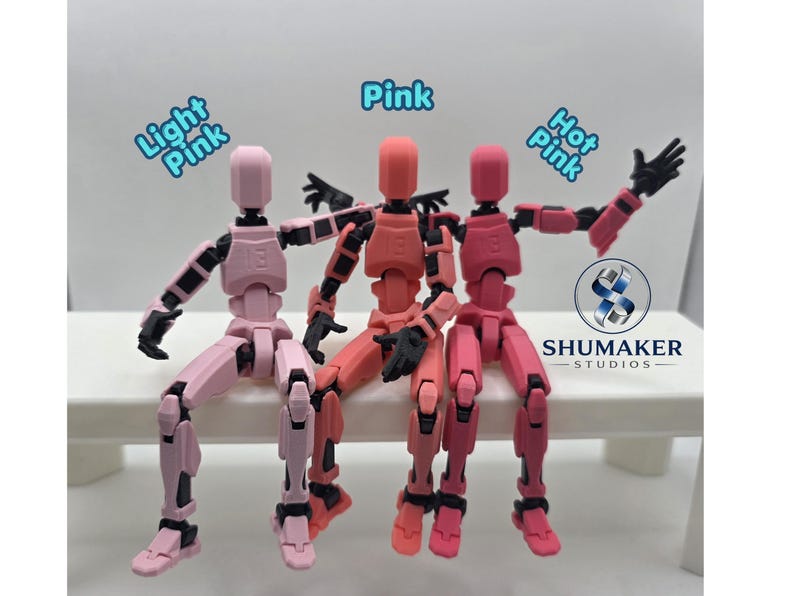 Może przedstawiać: Trzy przegubowe figurki akcji z czarnymi stawami, oznaczone jako Light Pink, Pink i Hot Pink. Figurki są w pozycji siedzącej. Logo Shumaker Studios jest widoczne po prawej stronie, wraz z tekstem Light Pink, Pink i Hot Pink.