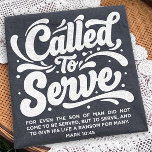 May include: A dark charcoal gray t-shirt featuring the white text "Called To Serve" in a large, stylized script font. Below this, smaller white text reads: "FOR EVEN THE SON OF MAN DID NOT COME TO BE SERVED, BUT TO SERVE, AND TO GIVE HIS LIFE A RANSOM FOR MANY. MARK 10:45."