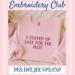May include: A light pink crewneck sweatshirt featuring the embroidered dark pink text I STAYED UP LATE FOR THE PLOT centered on the chest. The garment has long sleeves with ribbed cuffs and a ribbed neckline, presented in a clean, simple style.