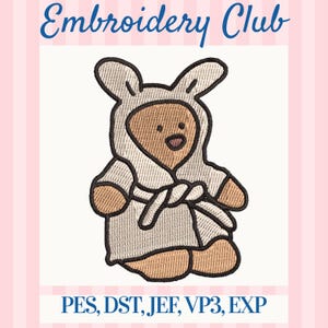 May include: An embroidered design featuring a teddy bear wearing a bunny-eared robe. The text "Embroidery Club" is at the top, with "PES, DST, JEF, VP3, EXP" at the bottom. The design is on a pink and white striped background.