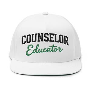 Peut inclure: Casquette blanche à visière plate avec l'inscription "COUNSELOR" en lettres noires en gras au-dessus de "Educator" en vert. La casquette a une visière verte et une couronne blanche.