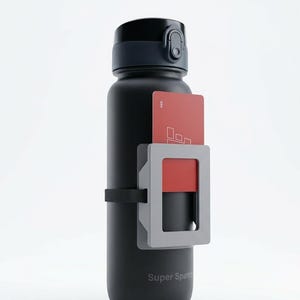 Könnte beinhalten: Schwarze Wasserflasche mit grauem und rotem Kartenhalter. Die Flasche hat einen schwarzen Deckel und einen schwarzen Riemen zur Sicherung des Kartenhalters. Der Text "Super Sparr" ist auf der Flasche aufgedruckt.