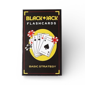 Op de afbeelding: Een rechthoekige doos met Black Jack Flashcards. De doos is zwart met gele accenten en heeft een afbeelding van speelkaarten en pokerchips. De tekst "BLACK JACK FLASHCARDS" en "BASIC STRATEGY" worden weergegeven.