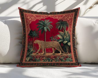 May include: Square decorative pillow with a red background featuring a walking leopard in a jungle scene with palm trees and lush greenery. The pillow has a decorative border with an ornate design.