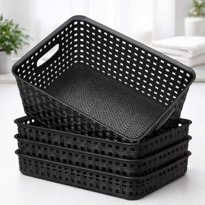 May include: A stack of four black rectangular storage baskets. The top basket has a handle and a perforated design. The interior of the baskets has a textured surface. The baskets are made of a woven material.