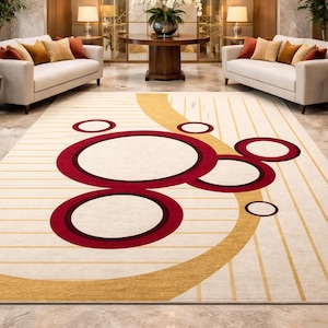 May include: A large, rectangular area rug with a cream background and a bold geometric design. The design features overlapping red circles and a curved gold accent. Vertical gold stripes add to the rug's pattern.