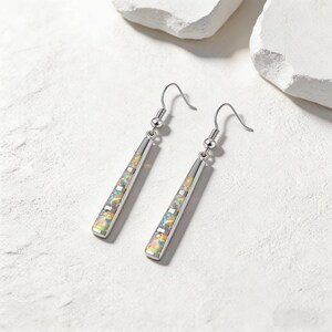 May include: A pair of silver-toned drop earrings featuring a long, slender bar design. Each earring is inlaid with multiple rectangular segments of iridescent, multi-colored opal-like stone, suspended from a simple curved ear wire hook.