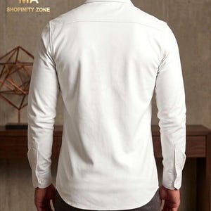 May include: A white long-sleeve button-down shirt. The shirt has a classic collar, buttoned cuffs, and a tailored fit. The text "MA SHOPINITY ZONE" is visible in the upper left corner.