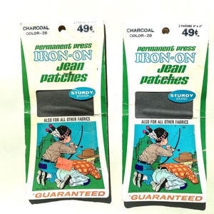 May include: Two vintage iron-on jean patches in charcoal color. Each package features a green and white design with the text "IRON-ON Jean patches" and a cartoon illustration of a child with a bow and arrow. The patches are 4 x 4 inches.