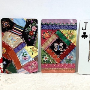 May include: Four playing cards: Ace of Hearts, a decorative card with a patchwork design, another decorative card with a patchwork design, and Jack of Clubs. The patchwork cards feature colorful fabric squares with floral and butterfly motifs.