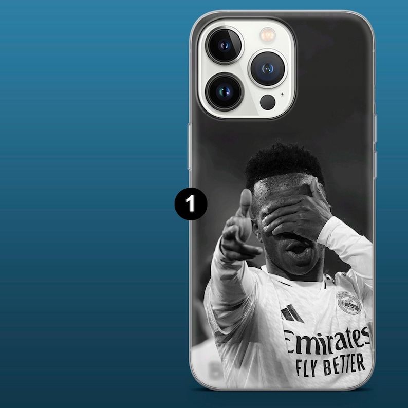 May include: A phone case featuring a black and white image of a soccer player in a white jersey. The player is pointing with one hand and covering his eyes with the other. The jersey has the text "Emirates FLY BETTER".