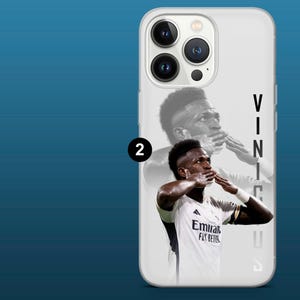 May include: White phone case featuring a portrait of a soccer player in a white jersey with the text "Emirates Fly Better". The player is blowing a kiss. The name "Vinicius" is printed vertically on the right side.