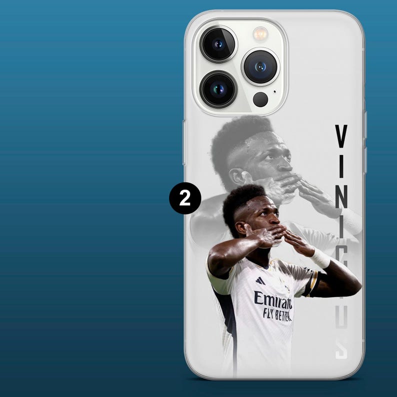 May include: White phone case featuring a portrait of a soccer player in a white jersey with the text "Emirates Fly Better". The player is blowing a kiss. The name "Vinicius" is printed vertically on the right side.