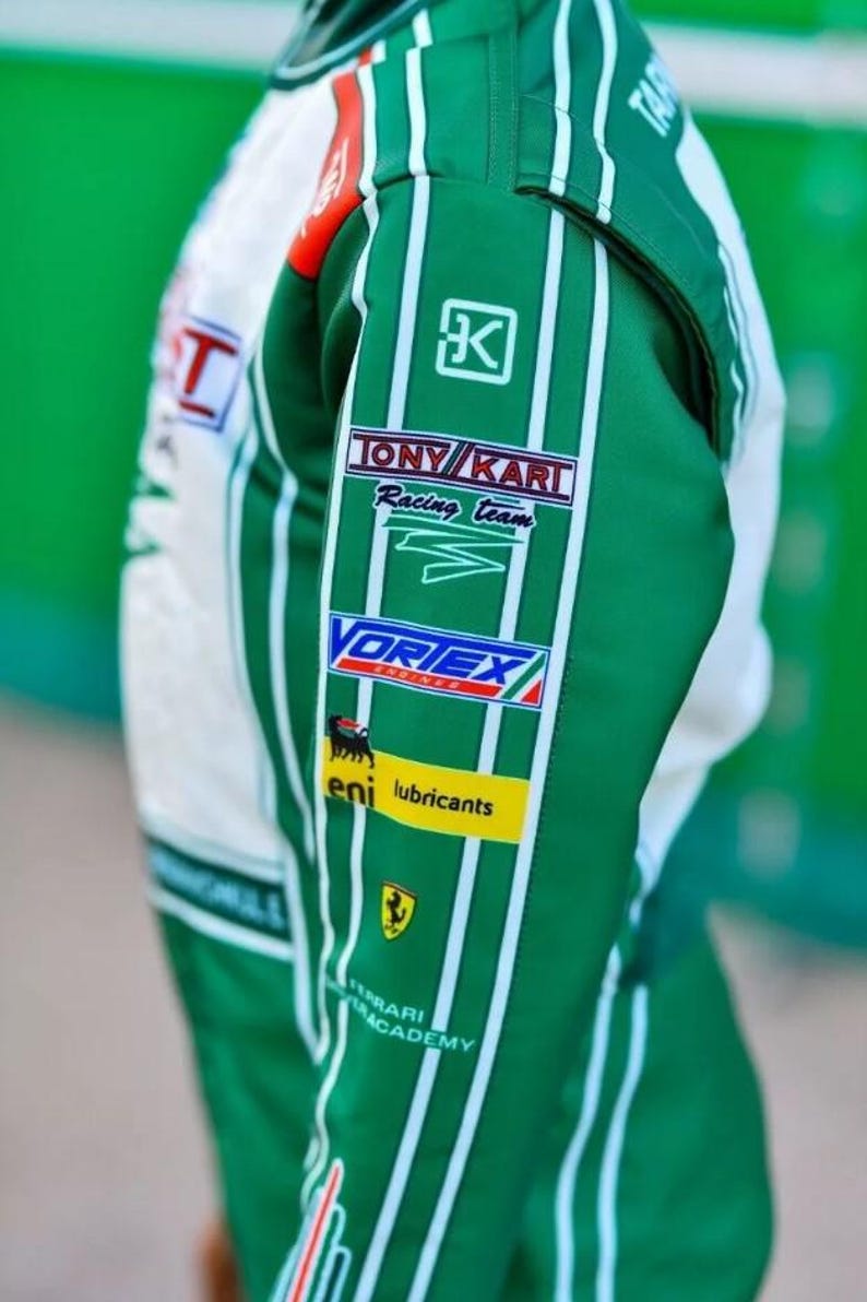 May include: Green and white racing suit with sponsor logos. The suit displays the "TONY KART Racing Team" logo, "VORTEX" logo, and "eni lubricants" logo. The Ferrari Academy logo is also visible.