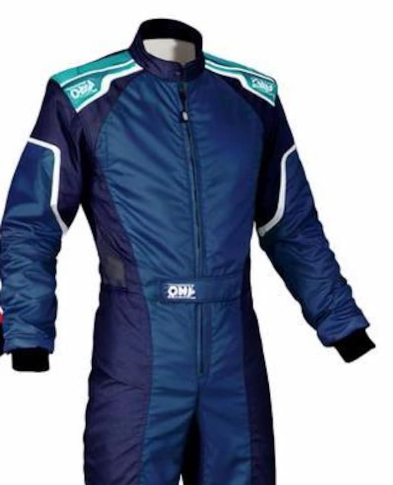 May include: A blue and dark blue racing suit featuring a high collar, a central zipper, and teal shoulder panels with white OMP branding. The long-sleeved garment includes white piping accents along the shoulders and arms, with black cuffs at the wrists.