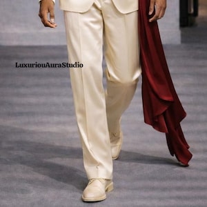 May include: Cream-colored suit with matching shoes. A flowing burgundy sash adds a pop of color. The text "LuxuriousAuraStudio" is visible. The suit appears to be made of a satin-like material, suggesting a formal or special occasion outfit.