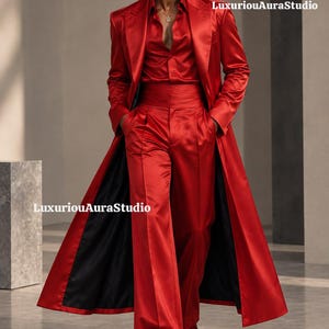 May include: A vibrant red satin ensemble featuring a long-line coat, a button-down shirt, and wide-leg trousers with a high-waisted cummerbund. The outfit includes dark sunglasses and a gold pendant necklace. Text reads LuxuriouAuraStudio.
