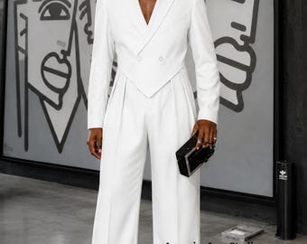 May include: A white double-breasted blazer with a sharp V-neckline and long sleeves, paired with matching high-waisted wide-leg trousers. The ensemble features a structured waistline and clean lines. The text LuxuriouAuraStudio is visible.
