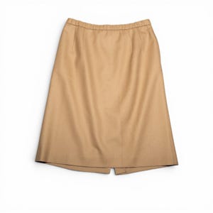 May include: A tan-colored skirt with a straight silhouette. The skirt has a simple design with a waistband and a slit at the back. The fabric appears to be a medium-weight material, suitable for various occasions.