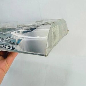 May include: A clear plastic package with a silver-colored cardboard backing. The package is partially visible, with a barcode and other printed information on the side. The contents are not fully visible.