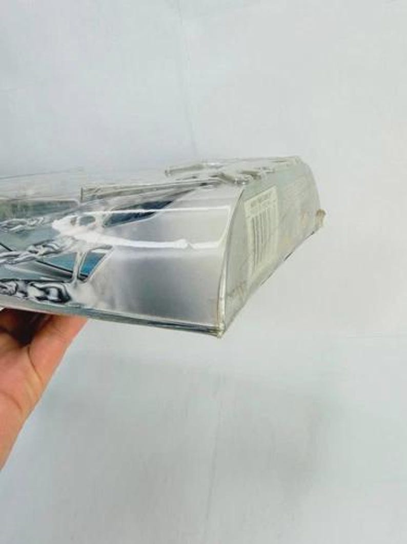 May include: A clear plastic package with a silver-colored cardboard backing. The package is partially visible, with a barcode and other printed information on the side. The contents are not fully visible.