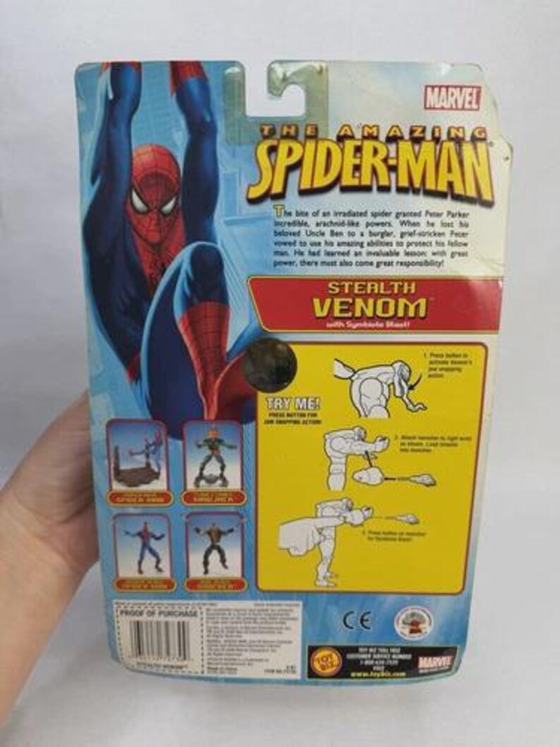 May include: The back of a Spider-Man action figure package. The package features a blue and red Spider-Man graphic, the text "The Amazing Spider-Man", and the words "Stealth Venom". The package also includes instructions and the Marvel logo.