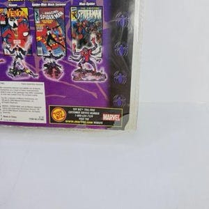 May include: A packaged Marvel Spider-Man action figure set. The packaging features comic book covers and character illustrations of Venom, Spider-Man, and Man-Spider. The text "COLLECT THEM ALL" is visible.