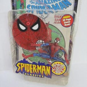 May include: A Spider-Man action figure in a plastic package. The figure is red and blue, with a red spider-web design on the chest. The packaging features the text "The Amazing Spider-Man" and "Spider-Man Classics". Includes a bonus 32-page comic book.