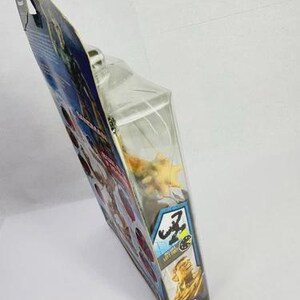 May include: A packaged action figure, featuring a yellow and orange creature. The packaging is a clear plastic blister pack attached to a cardboard backing with blue, red, and yellow graphics. The package has the text "Z" and "LEFT FOR".