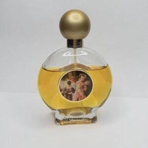 May include: A vintage perfume bottle with a clear, rounded glass body and a gold-colored spherical stopper. The bottle contains a golden liquid and features a circular label with a classical painting. The base is a clear, rectangular shape.
