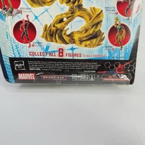 May include: A Marvel Spider-Man action figure package. The packaging is blue and white with images of Spider-Man and other characters. The text "COLLECT ALL 8 FIGURES" is visible. The Marvel and Spider-Man logos are also present.