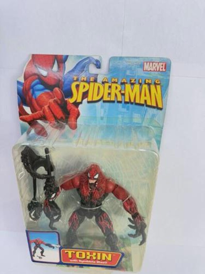 Puede incluir: Figura de acci&oacute;n de Toxin de la serie The Amazing Spider-Man. La figura es roja y negra, con un dise&ntilde;o de bestia simbionte. El embalaje incluye el logotipo de Marvel y la palabra "Toxin".
