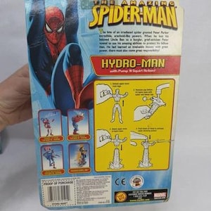 May include: The back of a Spider-Man action figure package. The package features a large image of Spider-Man in a blue and red suit, with the text "HYDRO-MAN" and instructions for use. The Marvel logo is at the top.