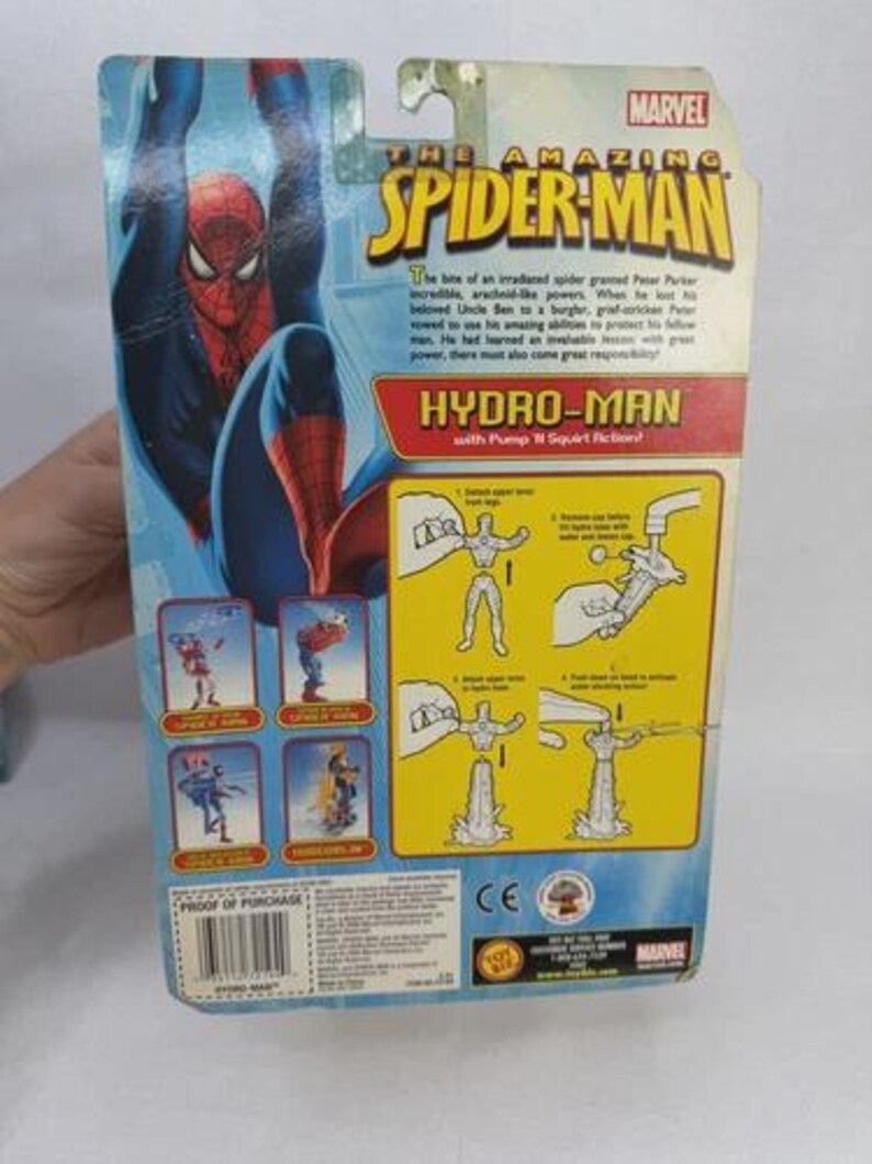 May include: The back of a Spider-Man action figure package. The package features a large image of Spider-Man in a blue and red suit, with the text "HYDRO-MAN" and instructions for use. The Marvel logo is at the top.