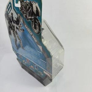 Puede incluir: Una figura de acci&oacute;n de Spider-Man en un embalaje de pl&aacute;stico transparente. El embalaje presenta un dise&ntilde;o azul y plateado con una imagen de Spider-Man en una motocicleta. La palabra "SPIDER-MAN" est&aacute; impresa en el embalaje.