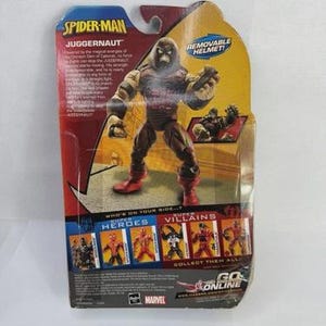 May include: A Spider-Man Juggernaut action figure in its original packaging. The figure is brown and tan with red boots. The packaging features the text "REMOVABLE HELMET!" and "COLLECT THEM ALL!"
