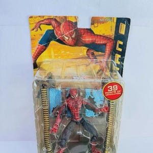 May include: Spider-Man action figure in a clear plastic package. The figure is red, blue, and black, with 39 points of articulation. The packaging features a Spider-Man graphic and the text "Spider-Man with Subway Accessory."