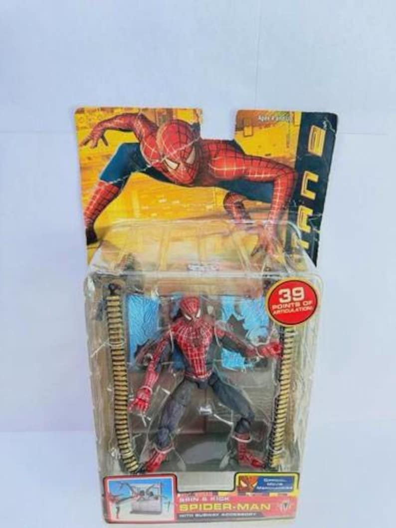 May include: Spider-Man action figure in a clear plastic package. The figure is red, blue, and black, with 39 points of articulation. The packaging features a Spider-Man graphic and the text "Spider-Man with Subway Accessory."