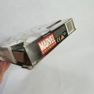 K&ouml;nnte beinhalten: Eine teilweise sichtbare, rechteckige Schachtel mit dem Marvel Universe-Logo in Rot und Wei&szlig;. Die Schachtel ist schwarz mit einem Barcode und Text auf der Seite. Die Schachtel wird vor einem wei&szlig;en Hintergrund gehalten.