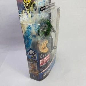 May include: A packaged Green Goblin action figure from the Spider-Man series. The figure is green and is in a clear plastic case. The packaging features a picture of the Green Goblin and the words "Build a Figure".