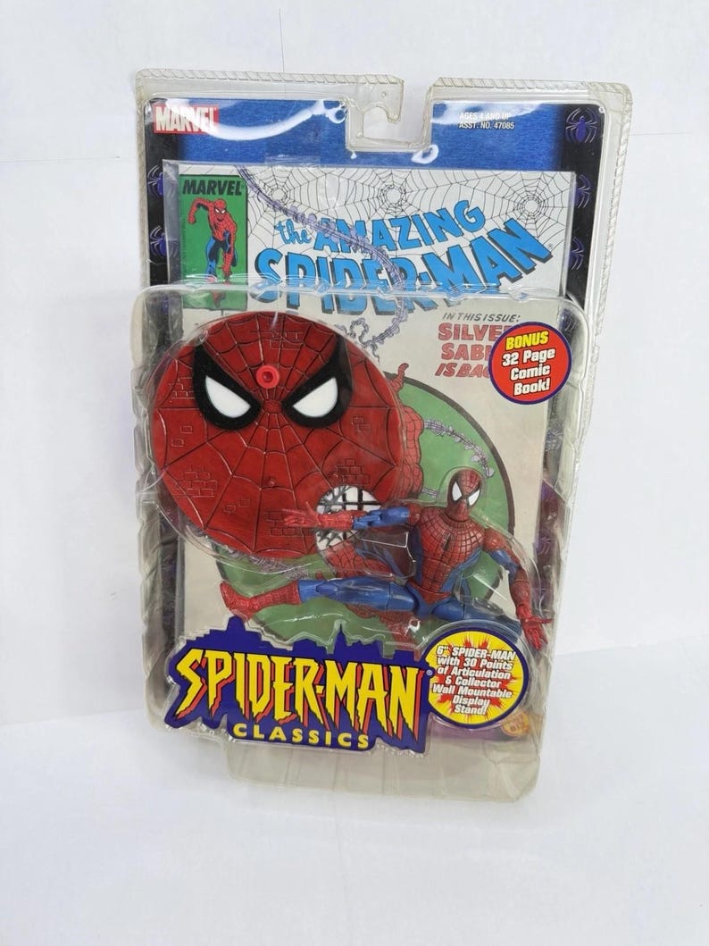 May include: A Spider-Man action figure in a clear plastic package. The figure is red and blue, with a comic book background. The packaging reads "SPIDER-MAN CLASSICS" and "THE AMAZING SPIDER-MAN".