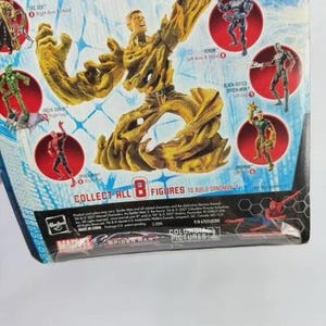 May include: A Sandman action figure from the Marvel Collection series. The figure is primarily tan and brown, with a detailed, textured design. The packaging features other figures and the text "COLLECT ALL 8 FIGURES TO BUILD SANDMAN".
