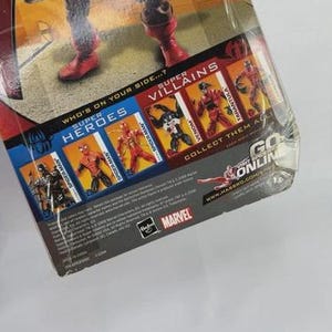 May include: A packaged action figure of a superhero in a red and blue costume with red boots. The packaging features the words "Super Heroes" and "Super Villains" with images of other characters. The Marvel logo is visible.