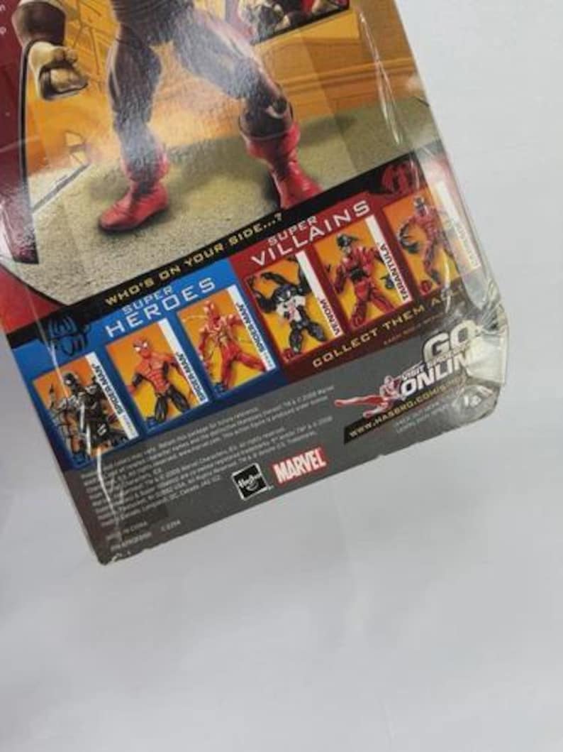May include: A packaged action figure of a superhero in a red and blue costume with red boots. The packaging features the words "Super Heroes" and "Super Villains" with images of other characters. The Marvel logo is visible.