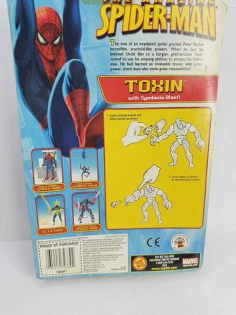 Puede incluir: La parte trasera de un paquete de figuras de acci&oacute;n de Spider-Man. El paquete presenta una gran ilustraci&oacute;n de Spider-Man y el texto "TOXIN with Symbiote Blast!" junto con otros personajes de Spider-Man.
