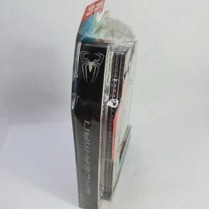 Puede incluir: Embalaje sellado del producto Spider-Man. El embalaje negro presenta un logotipo de ara&ntilde;a blanco y las palabras "SPIDER-MAN" en blanco. El embalaje es transparente en la parte delantera, revelando el producto en el interior. La parte superior del embalaje es roja y azul.