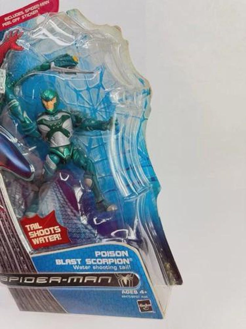 Puede incluir: Figura de acci&oacute;n Poison Blast Scorpion de la serie Spider-Man, en un bl&iacute;ster transparente. La figura es verde y plateada, con una cola que dispara agua. El embalaje incluye el texto "Tail Shoots Water!"